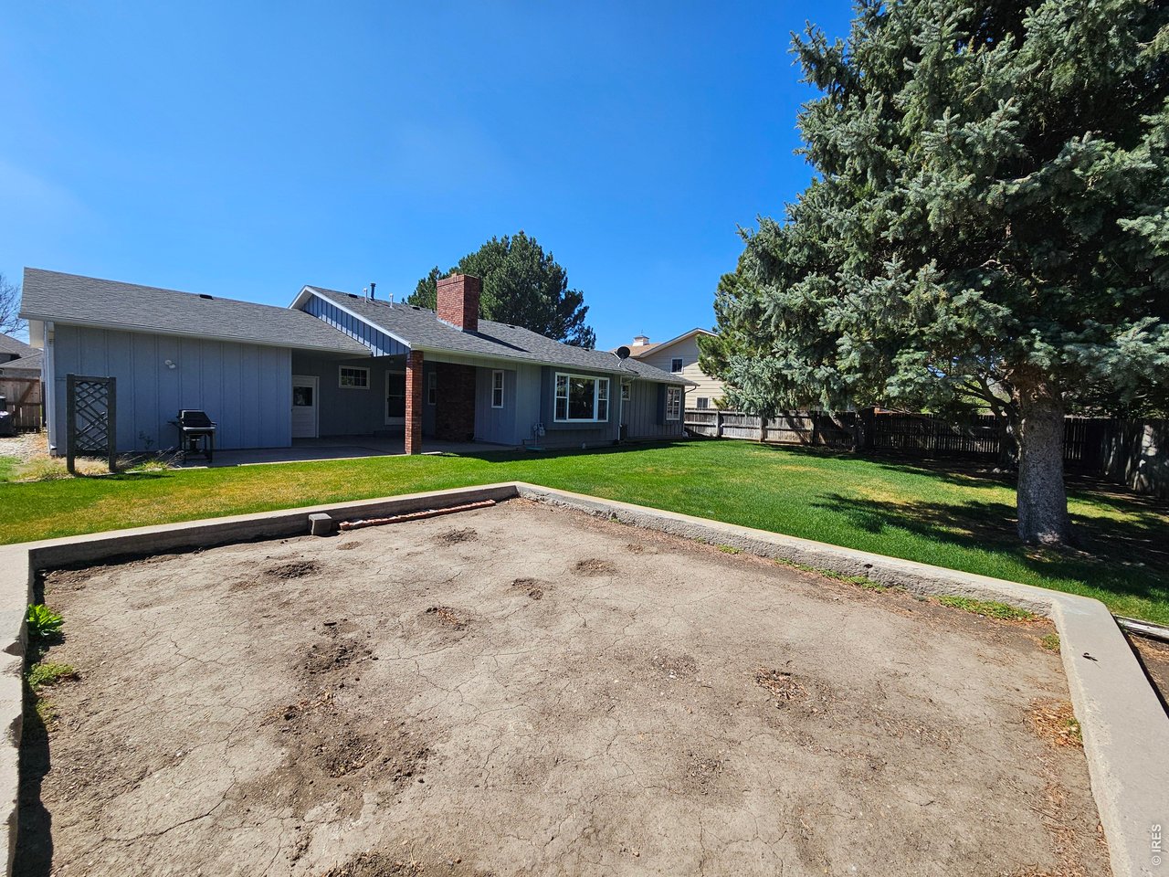 1010 Fairhurst Street Sterling, CO 80751 - Photo 33 of 36 a view of a house with a big yard and large trees