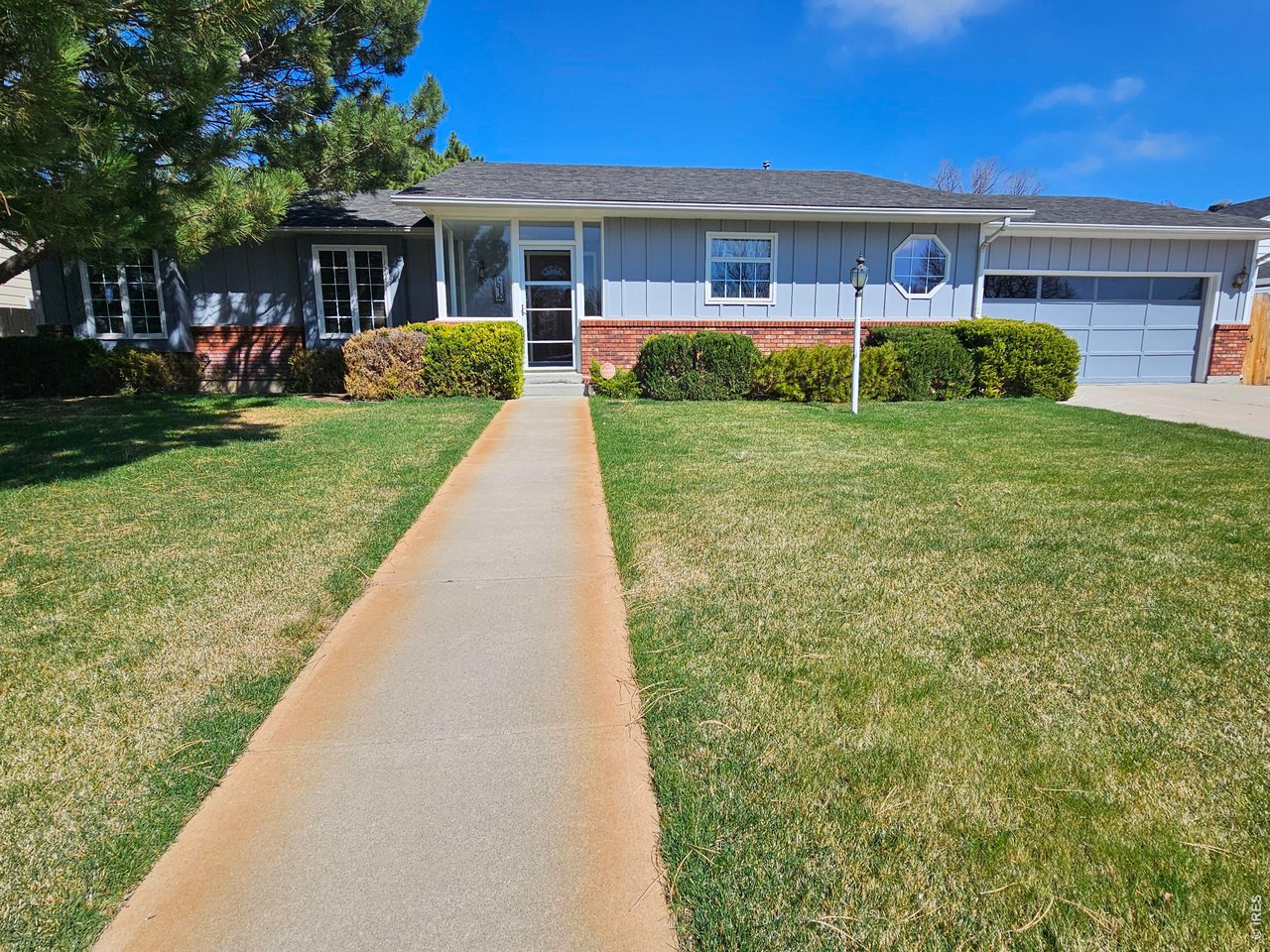 1010 Fairhurst Street Sterling, CO 80751 - Photo 35 of 36 a front view of a house with a yard and potted plants