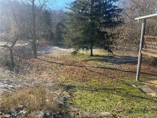 a view of a yard with wooden fence