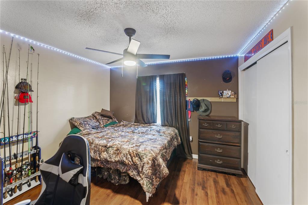 8715 Huntsman Lane Port Richey, FL 34668 - Photo 33 of 54 a bedroom with a bed and wooden floor