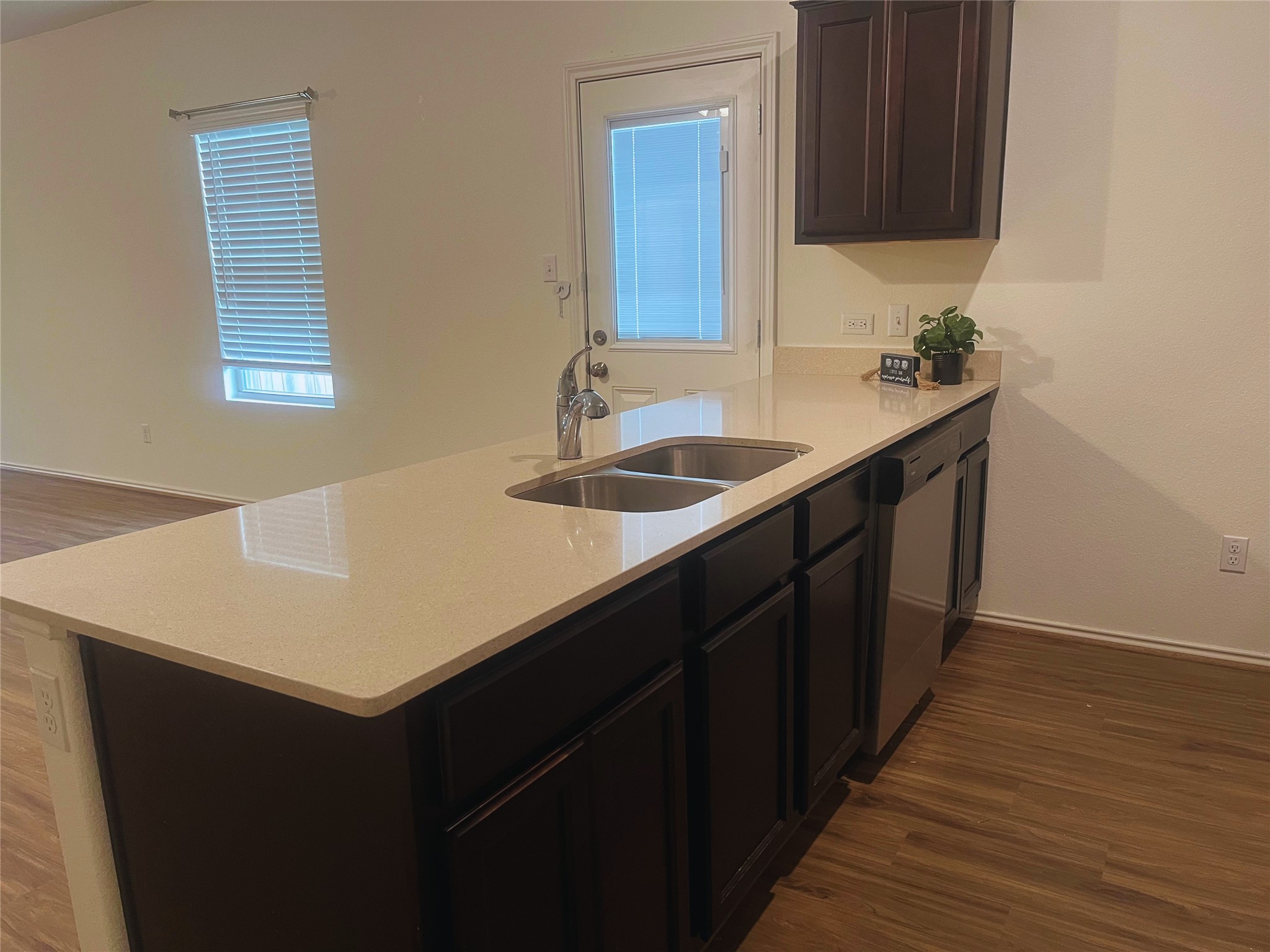 117 Galaxy Way Jarrell, TX 76537 - Photo 8 of 17 Kitchen island featuring a double basin stainless steel sink, a chrome faucet, and light-toned countertops