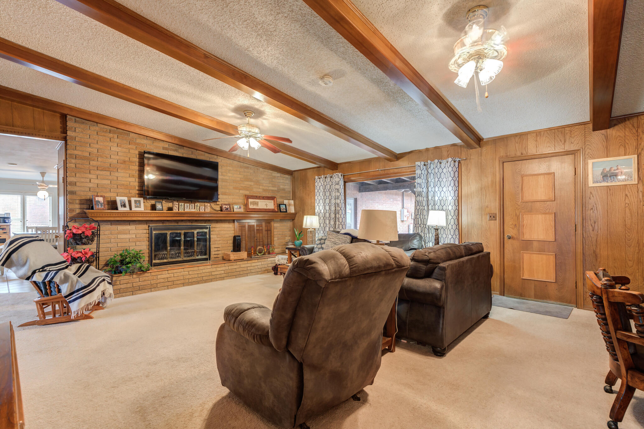 902 West 6th Street Idalou, TX 79329 - Photo 6 of 42 a living room with furniture a flat screen tv and a fireplace