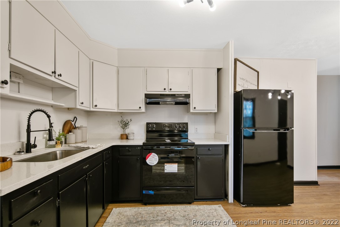 2743 George Owen Road Fayetteville, NC 28306 - Photo 18 of 47 a kitchen with a refrigerator sink and cabinets