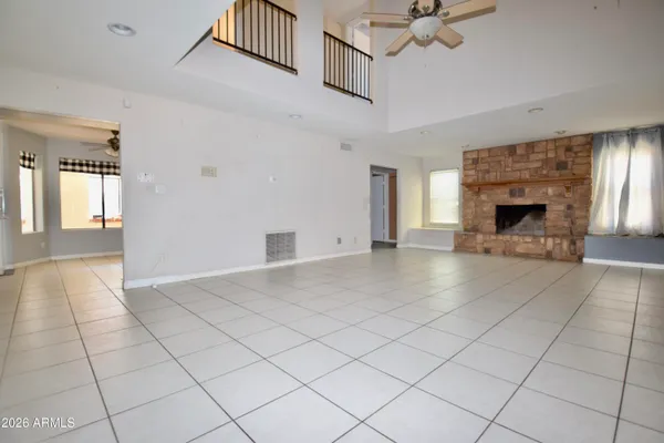 a view of a livingroom with a fireplace a chandelier and windows