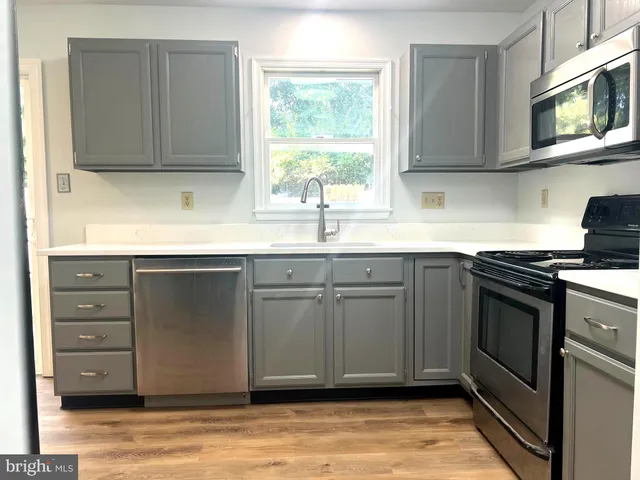 a kitchen with stainless steel appliances granite countertop a sink stove and cabinets