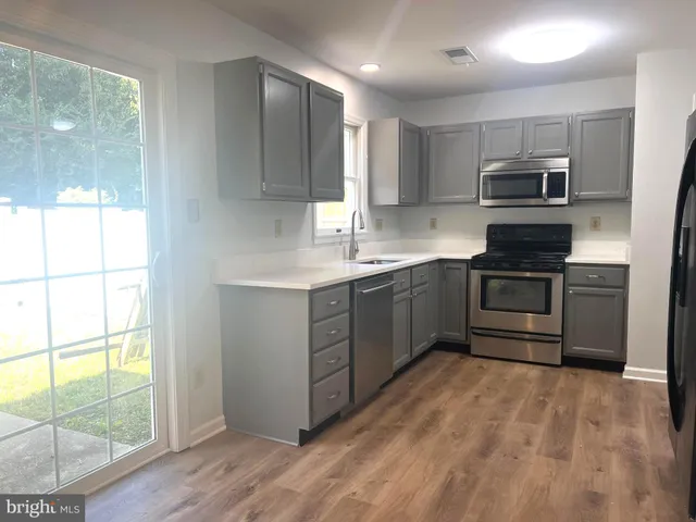 a kitchen with stainless steel appliances a stove sink and cabinets