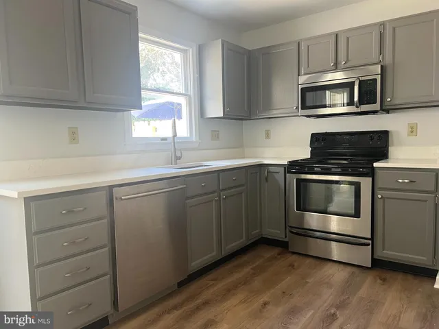a kitchen with sink a microwave and cabinets