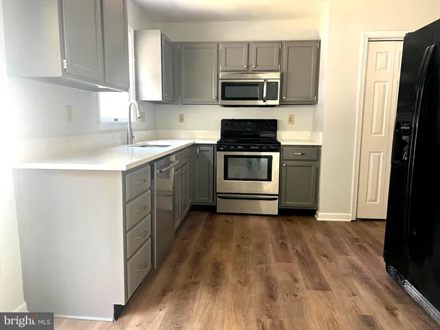 a kitchen with a sink stove and refrigerator