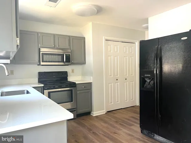 a kitchen with granite countertop a refrigerator stove and microwave