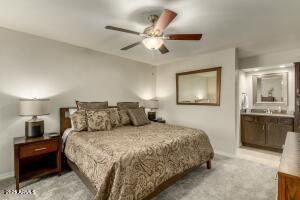 4850 East Desert Cove Avenue, Unit 227 Scottsdale, AZ 85254 - Photo 12 of 32 a bedroom with a large bed and a chandelier