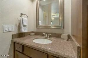 a bathroom with a granite countertop sink and a mirror