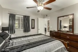 a bedroom with a large bed and a flat tv screen on dresser