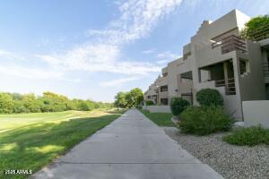 4850 East Desert Cove Avenue, Unit 227 Scottsdale, AZ 85254 - Photo 24 of 32 a view of a white house next to a yard with big trees