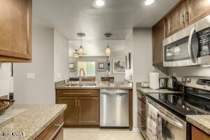 4850 East Desert Cove Avenue, Unit 227 Scottsdale, AZ 85254 - Photo 5 of 32 a kitchen with stainless steel appliances granite countertop a sink stove and refrigerator