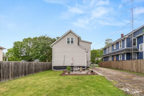 a view of a house with a yard and sitting area