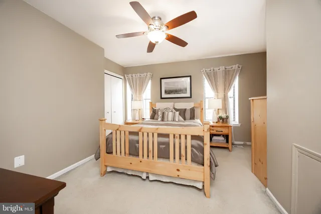a view of a bedroom with furniture window and a ceiling fan