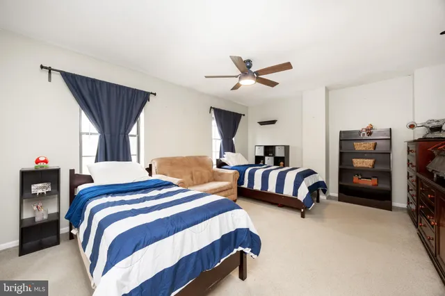 a spacious bedroom with a bed a couch and a chandelier