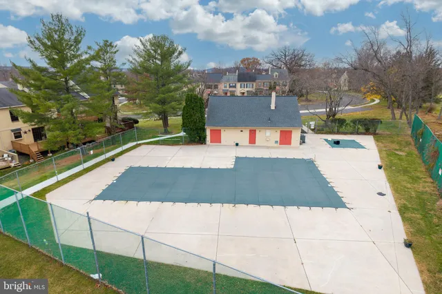 an aerial view of a house with swimming pool and a yard