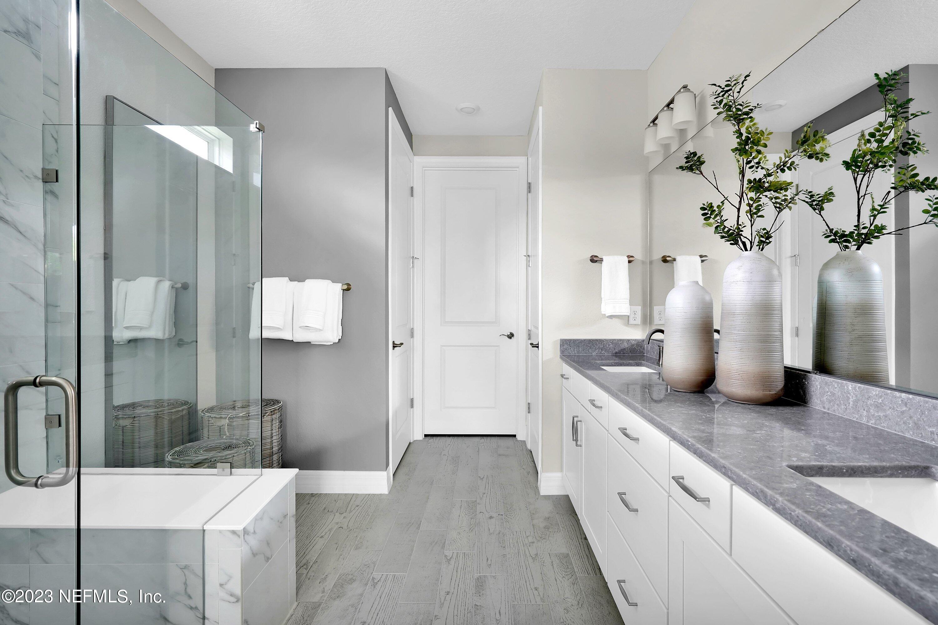 384 Del Webb Parkway Yulee, FL 32097 - Photo 20 of 35 a spacious bathroom with a granite countertop sink a mirror and shower