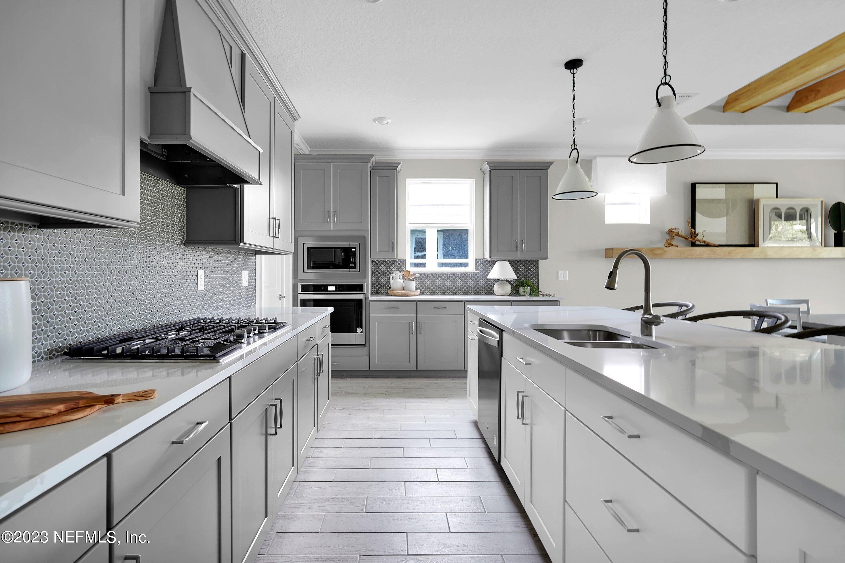384 Del Webb Parkway Yulee, FL 32097 - Photo 8 of 35 a kitchen with stainless steel appliances granite countertop a sink stove and cabinets