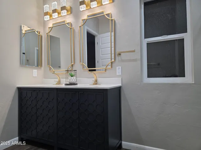 a bathroom with double vanity and a mirror