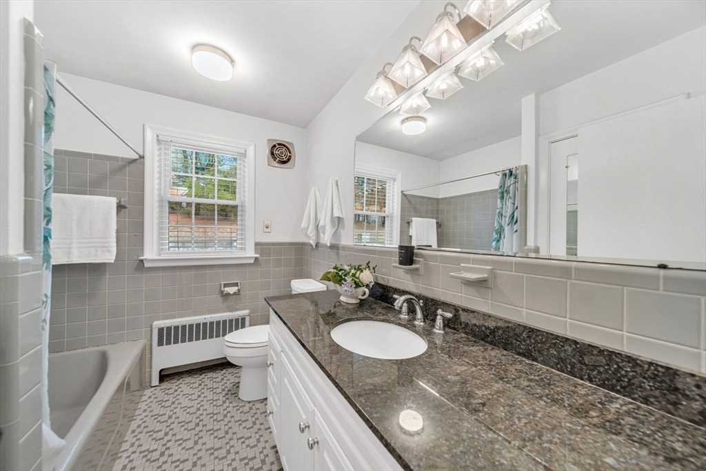 15 Spring Valley Road Belmont, MA 02478 - Photo 18 of 29 a bathroom with a granite countertop sink a toilet a mirror and shower