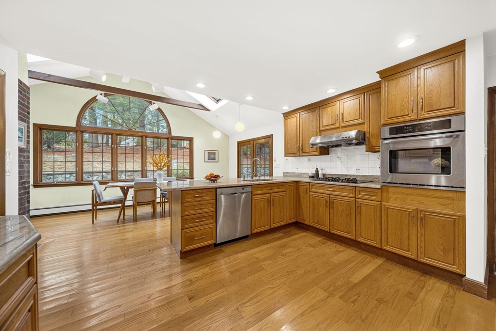 15 Spring Valley Road Belmont, MA 02478 - Photo 8 of 29 a kitchen with stainless steel appliances wooden floors and white cabinets