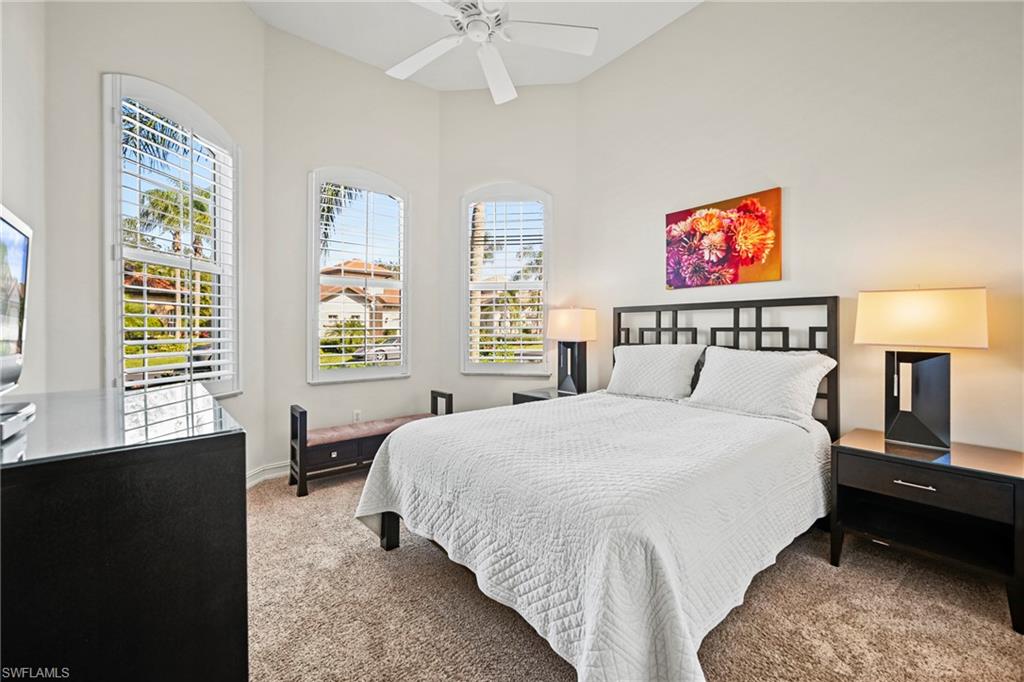 12592 Grandezza Circle Estero, FL 33928 - Photo 21 of 40 a spacious bedroom with a bed and a chandelier