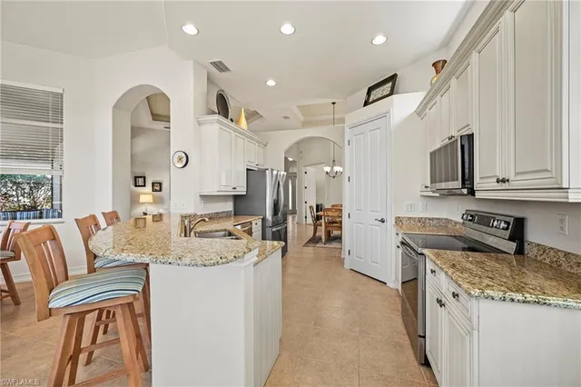 a large kitchen with stainless steel appliances granite countertop a lot of counter space and a sink