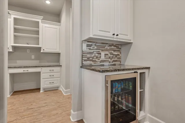 a kitchen with white cabinets and a fireplace