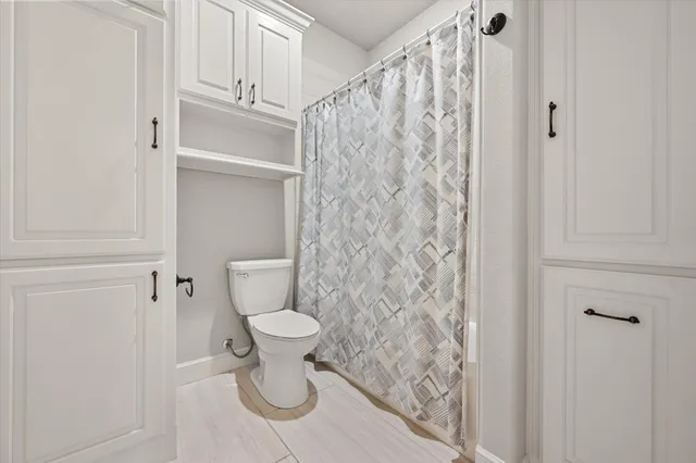 a bathroom with a toilet and a shower curtain