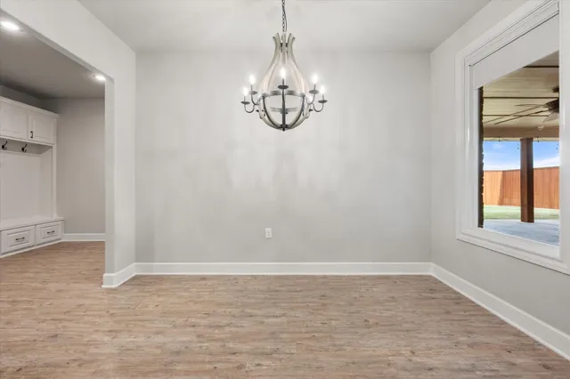 a view of empty room with window and chandelier
