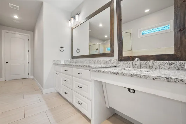 a bathroom with a granite countertop sink mirror and bathtub