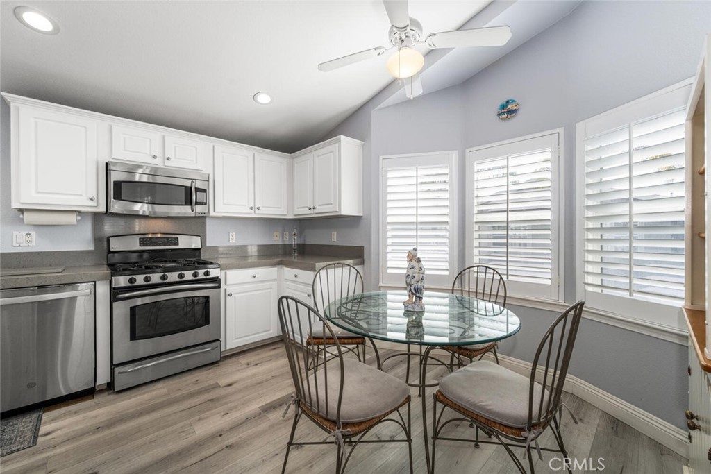 16222 Monterey Lane, Unit 371 Huntington Beach, CA 92649 - Photo 11 of 70 a kitchen with kitchen island granite countertop a stove a microwave a dining table and chairs
