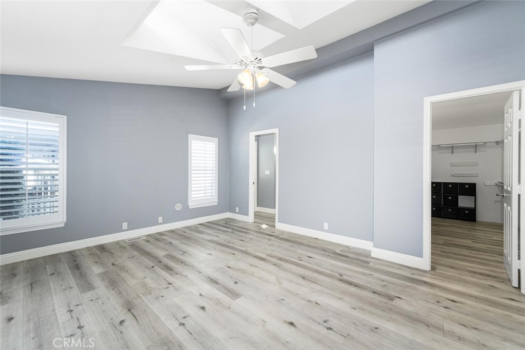 16222 Monterey Lane, Unit 371 Huntington Beach, CA 92649 - Photo 27 of 70 an empty room with wooden floor fan and windows