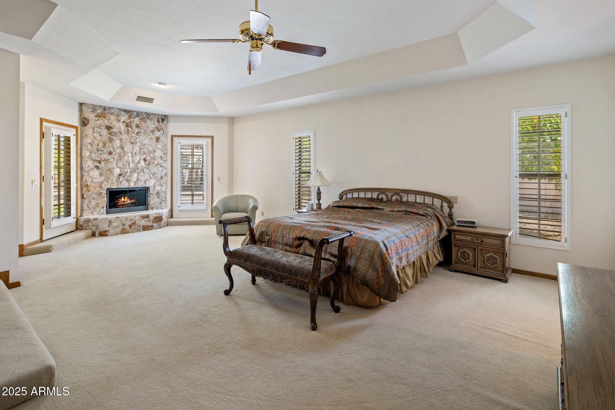 8815 North Invergordon Road Paradise Valley, AZ 85253 - Photo 12 of 22 a spacious bedroom with a bed and a fireplace