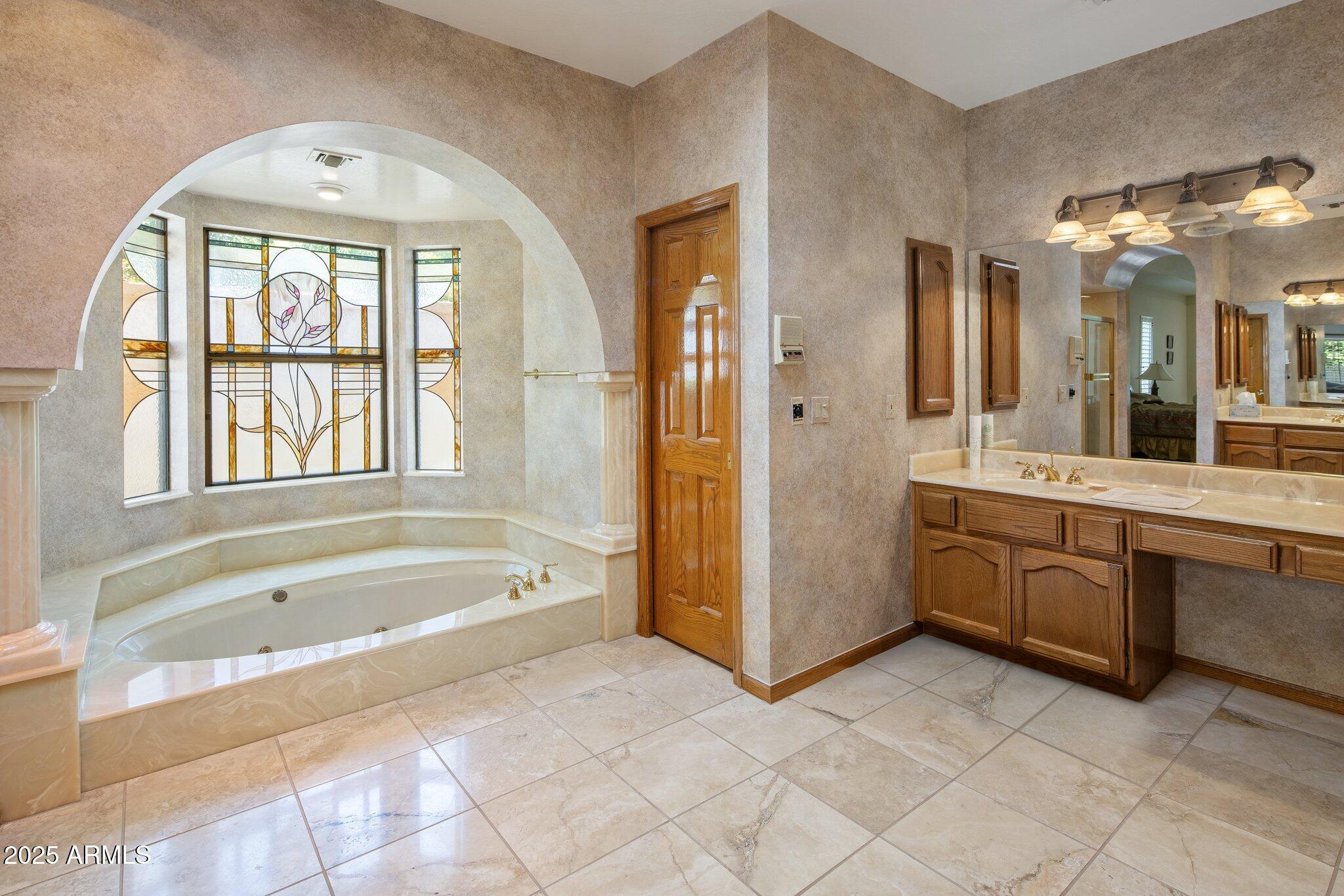 8815 North Invergordon Road Paradise Valley, AZ 85253 - Photo 13 of 22 a spacious bathroom with a tub sink and mirror