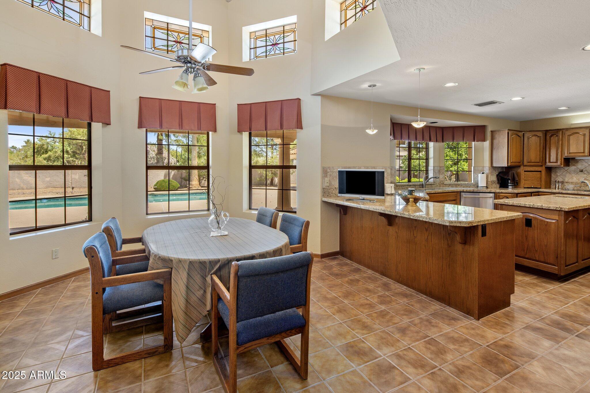 8815 North Invergordon Road Paradise Valley, AZ 85253 - Photo 7 of 22 a kitchen with granite countertop a sink and chairs