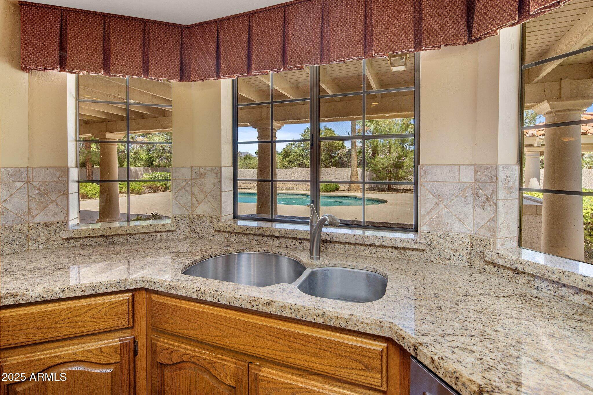 8815 North Invergordon Road Paradise Valley, AZ 85253 - Photo 10 of 22 a kitchen with granite countertop a sink and a refrigerator