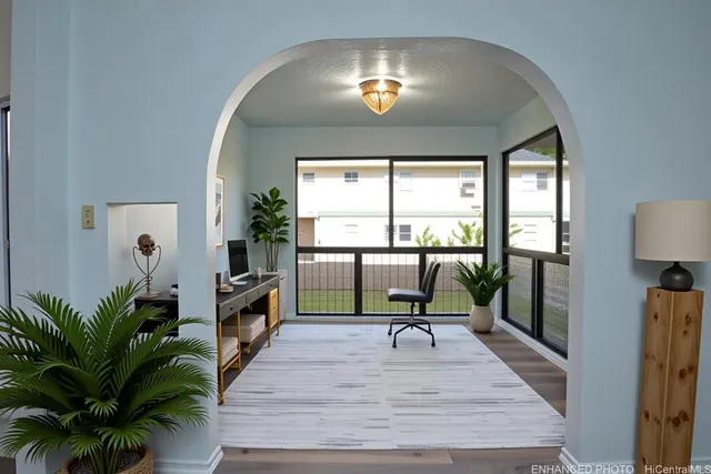 a living room with furniture and a large window with potted plants
