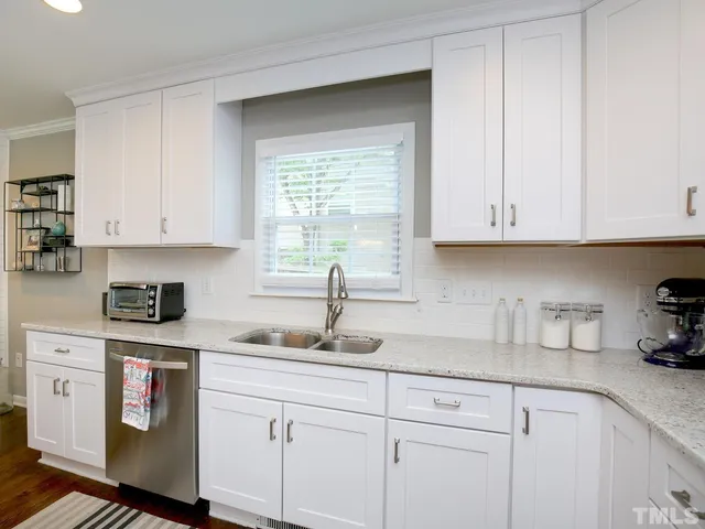 a kitchen with granite countertop white cabinets and white appliances