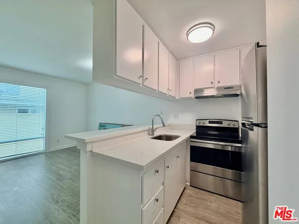 a kitchen with a sink stove top oven and cabinets