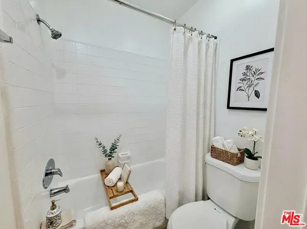 a bathroom with a toilet and a shower curtain