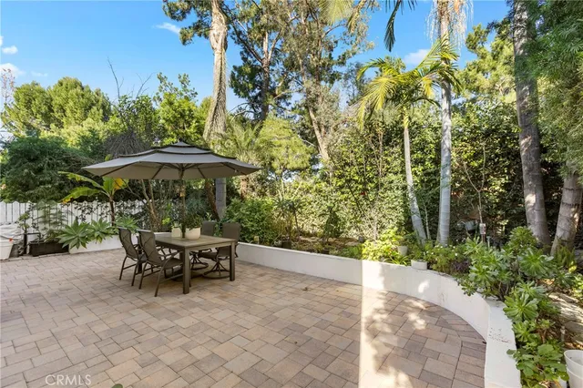 a view of patio with a table and chairs under an umbrella