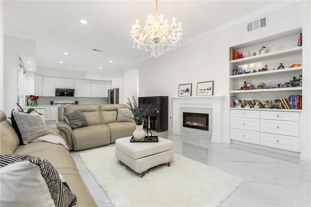 a living room with furniture a fireplace and a chandelier