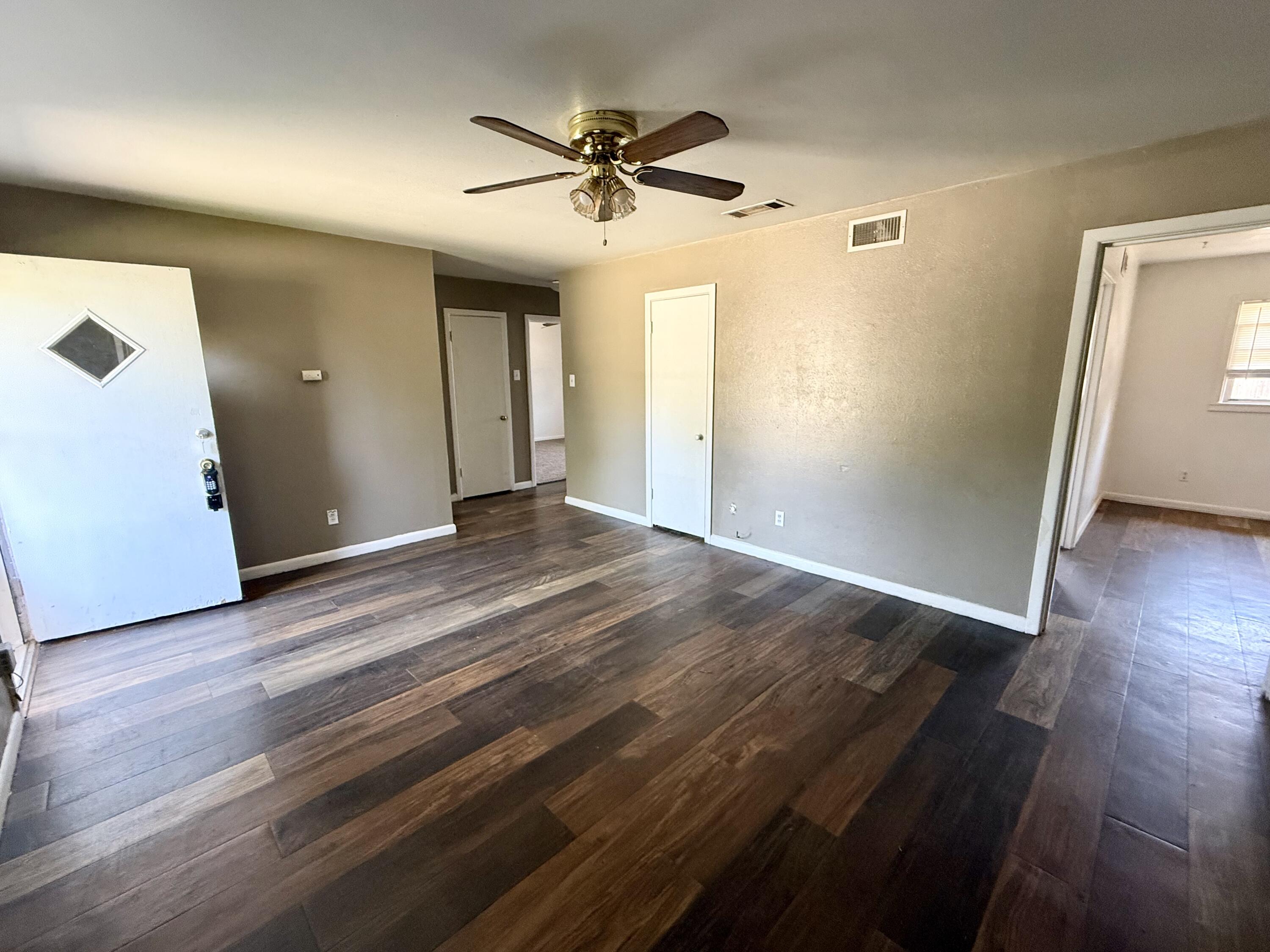 2817 63rd Street Lubbock, TX 79413 - Photo 2 of 16 wooden floor in an empty room with a window