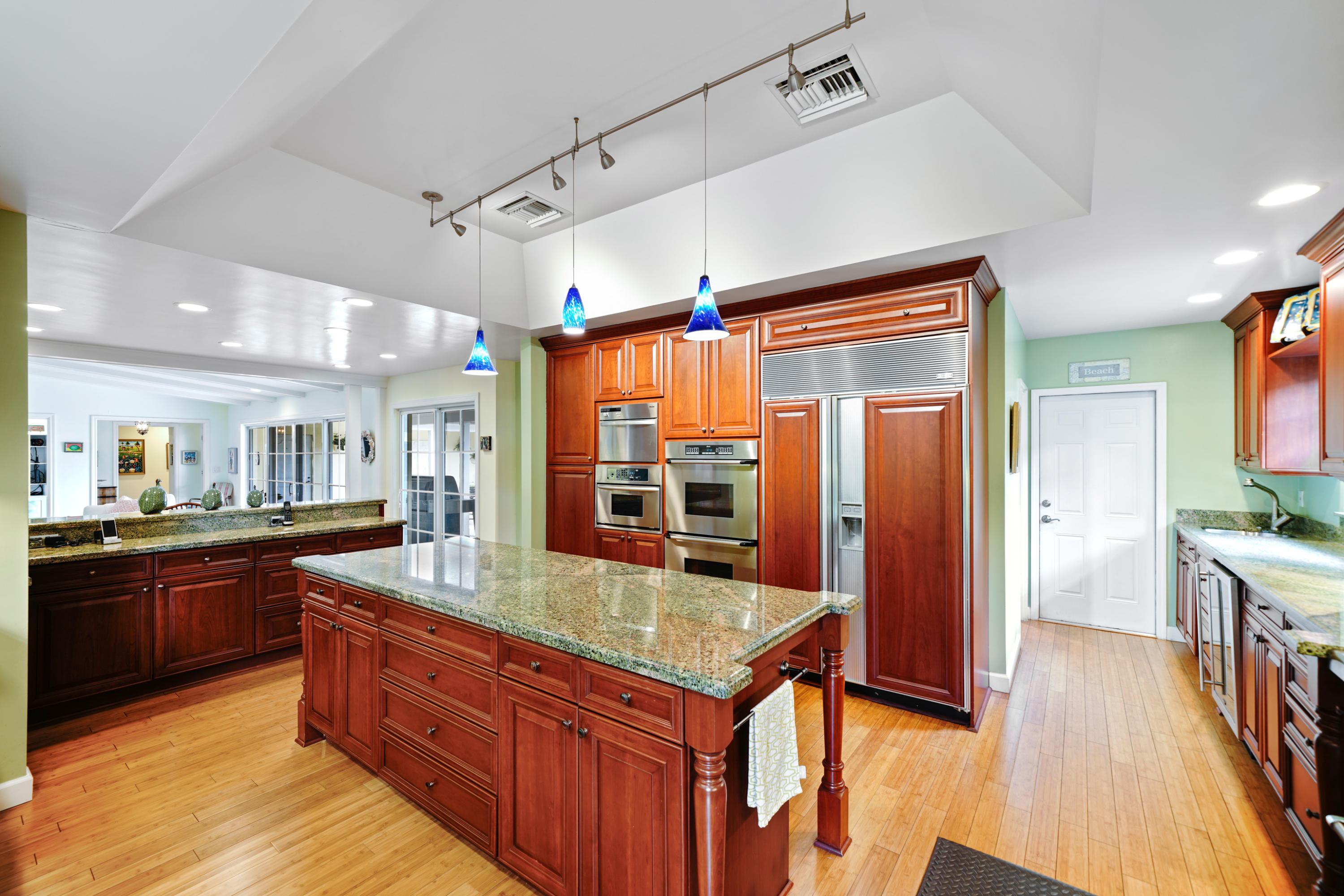 3232 Gulf Stream Road Gulf Stream, FL 33483 - Photo 26 of 36 a kitchen with stainless steel appliances granite countertop a refrigerator a sink dishwasher a stove and a dining table with wooden floor