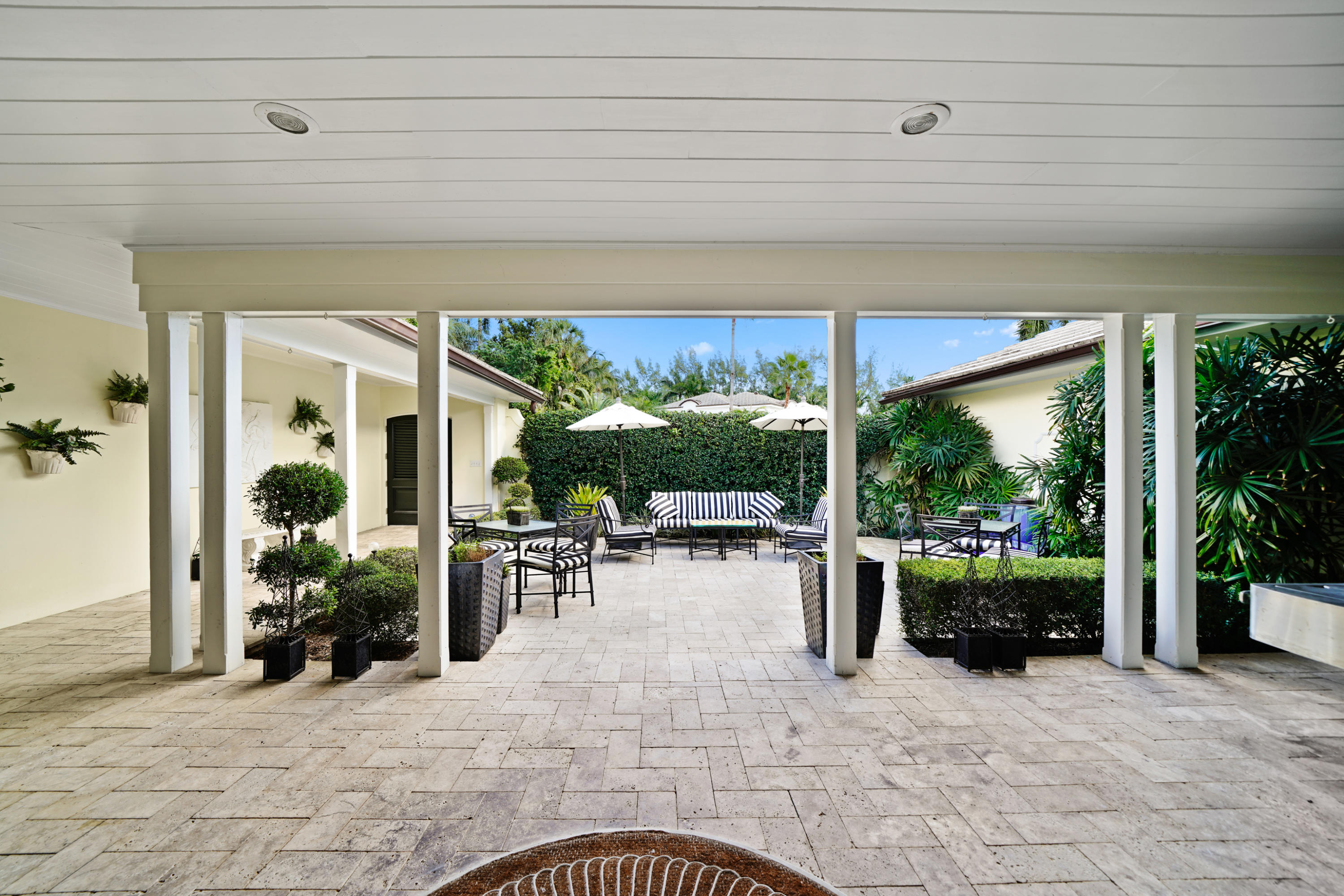 3232 Gulf Stream Road Gulf Stream, FL 33483 - Photo 5 of 36 a view of a patio with table and chairs potted plants and floor to ceiling window