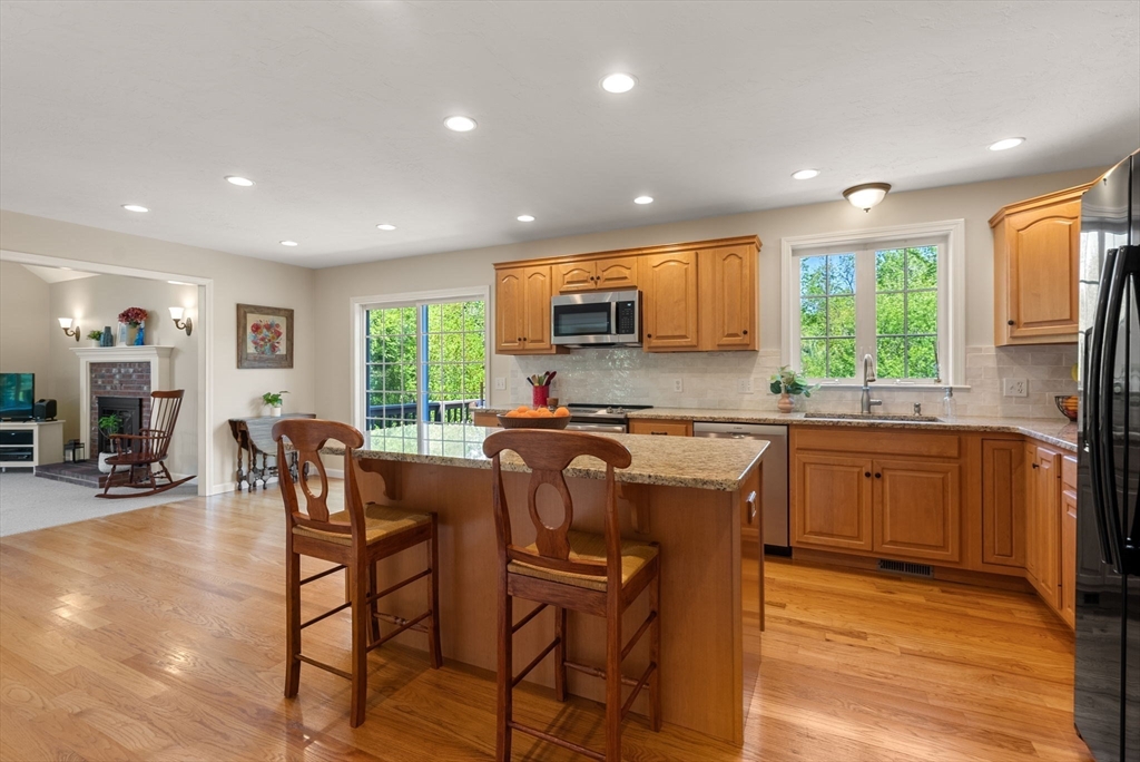 7 Brook Hill Road Sturbridge, MA 01518 - Photo 17 of 41 a kitchen with stainless steel appliances granite countertop wooden cabinets a refrigerator a stove a sink and a dining table with wooden floor