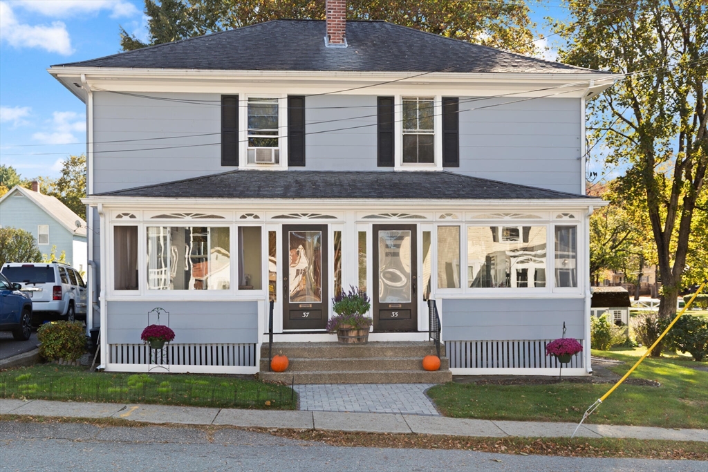 a front view of a house with a garden and trees